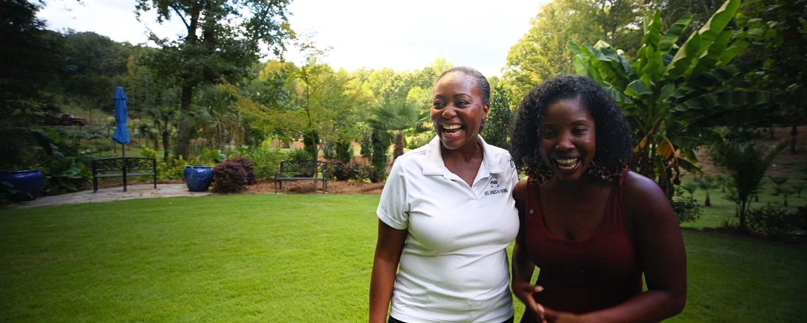 Host of This Is Atlanta: South DeKalb Edition and Chief Experience Officer of Arabia Mountain Vineyard embracing and laughing