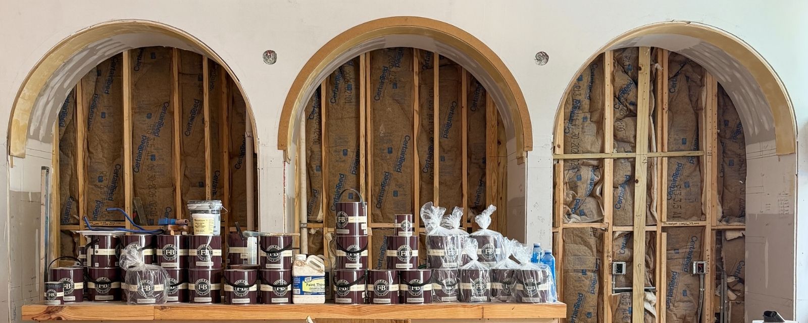 Paint on a table with three spanish arches behind the table for the Little Tart Bakery Renovation